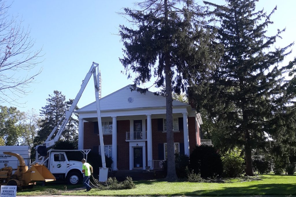 Greenland Tree Service bucket truck and chipper removing a tree at a home in the Minonk, IL area